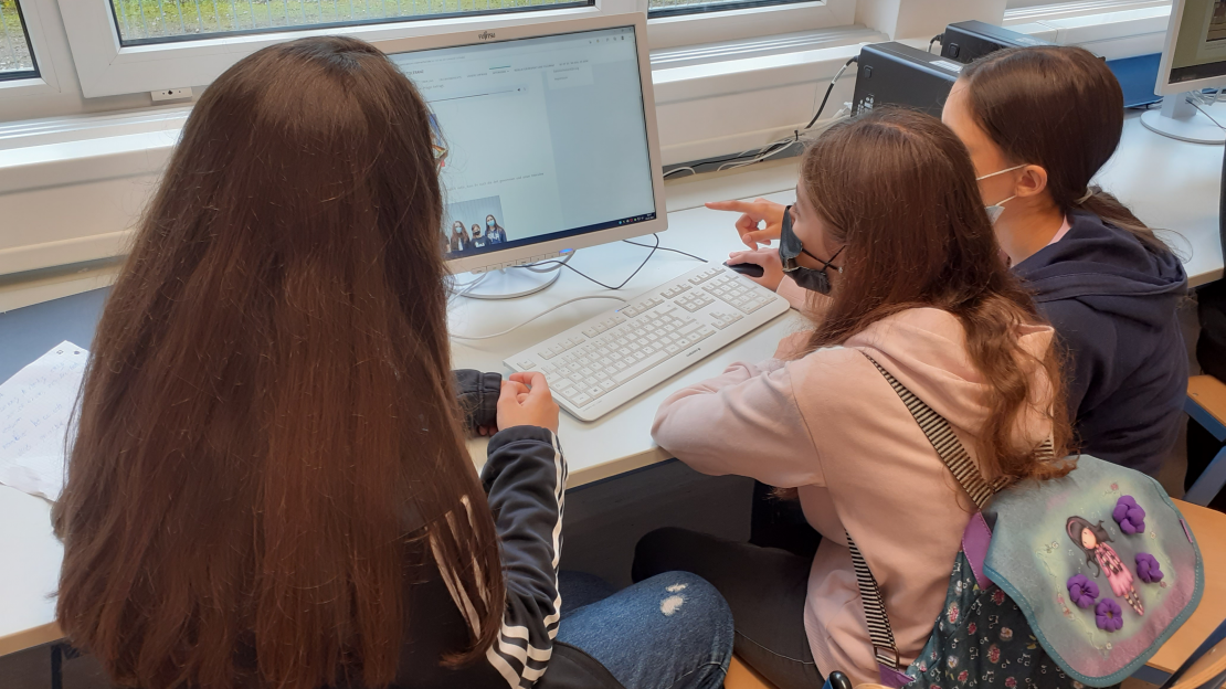Drei Schüler:innen vor einem Computer beim Aufbau einer Homepage zum Thema "Respekt und Toleranz"